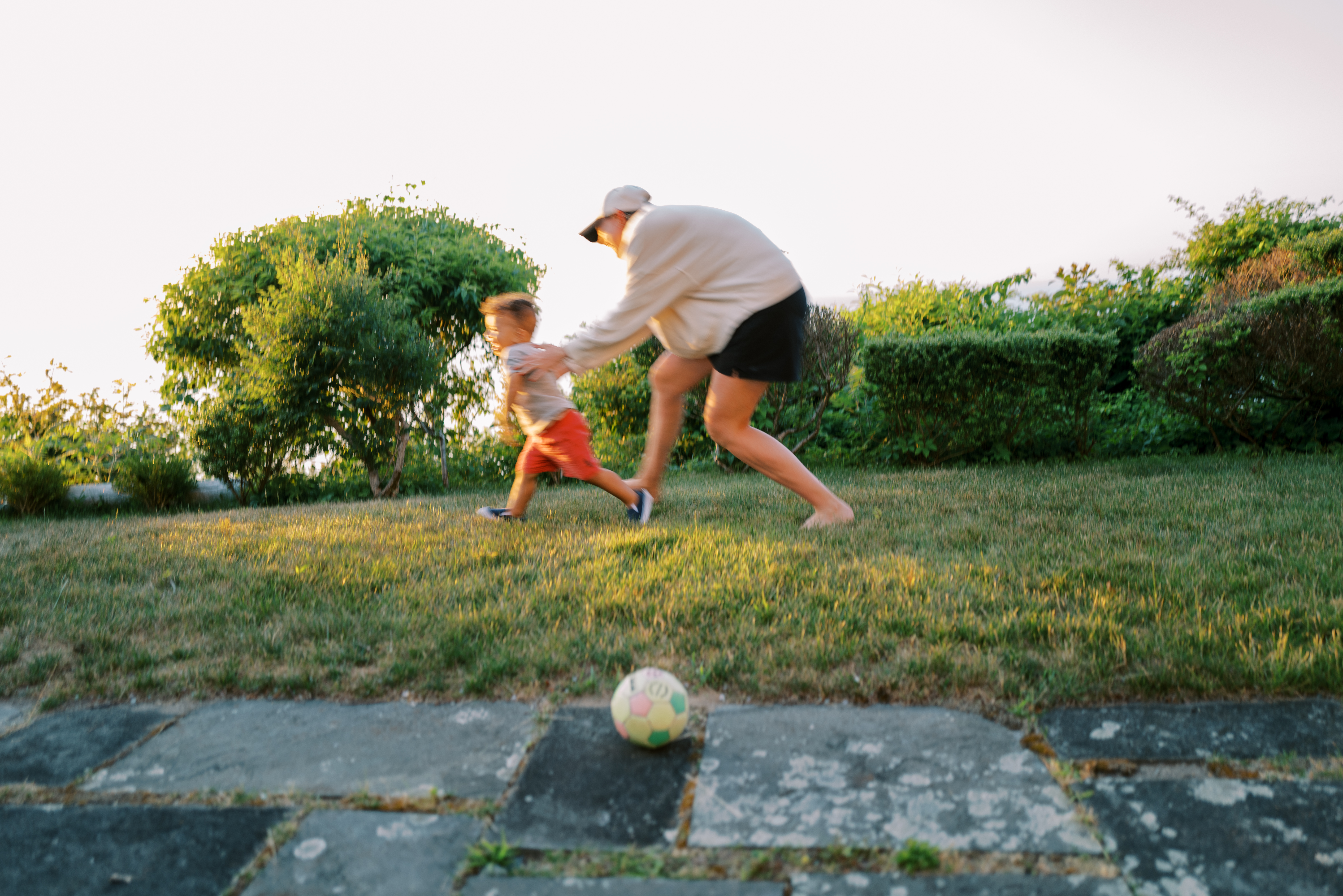 Jesse chasing her son across the grass at golden hour