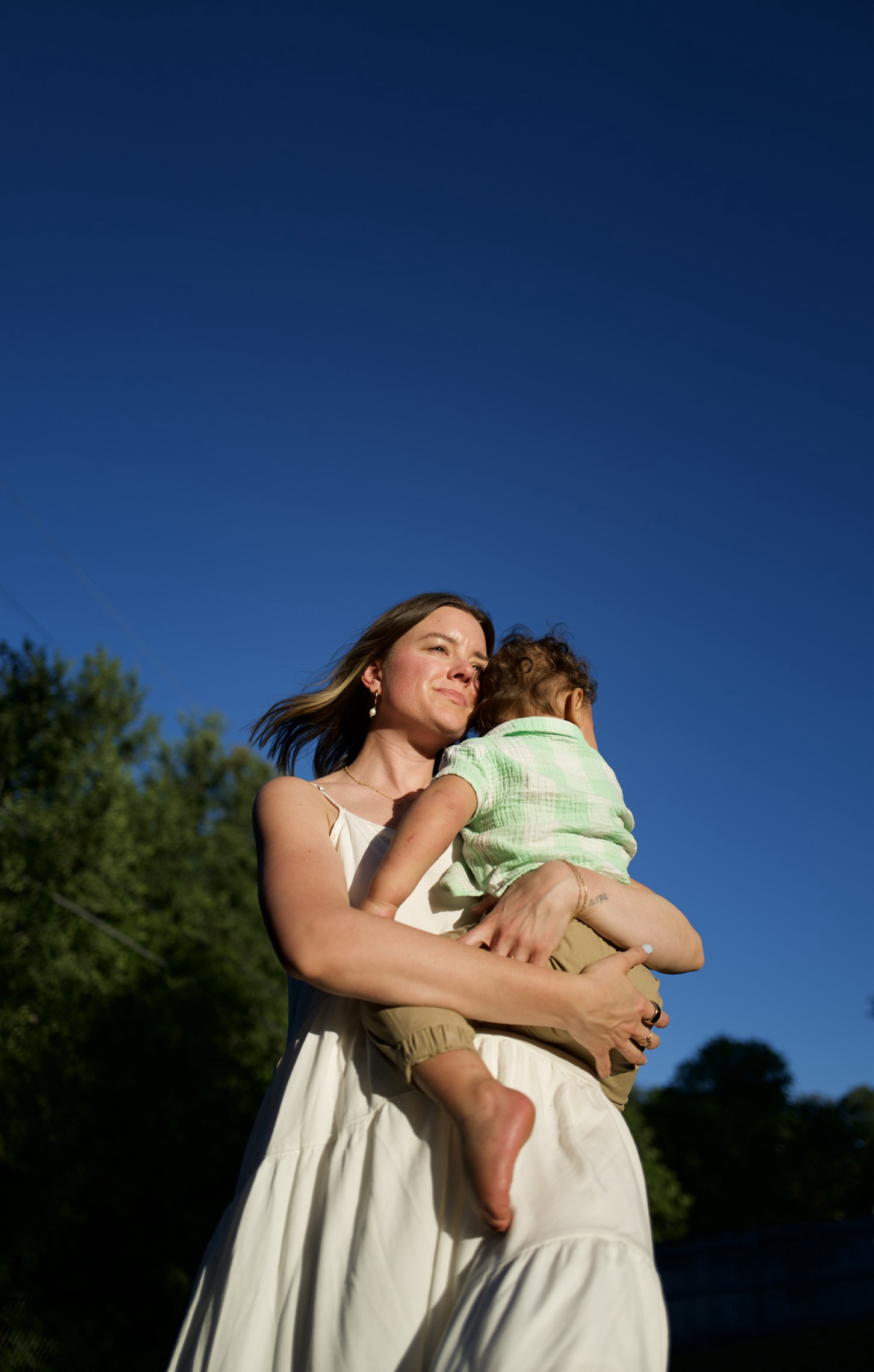 Jesse Frazier holding her son outdoors in golden light
